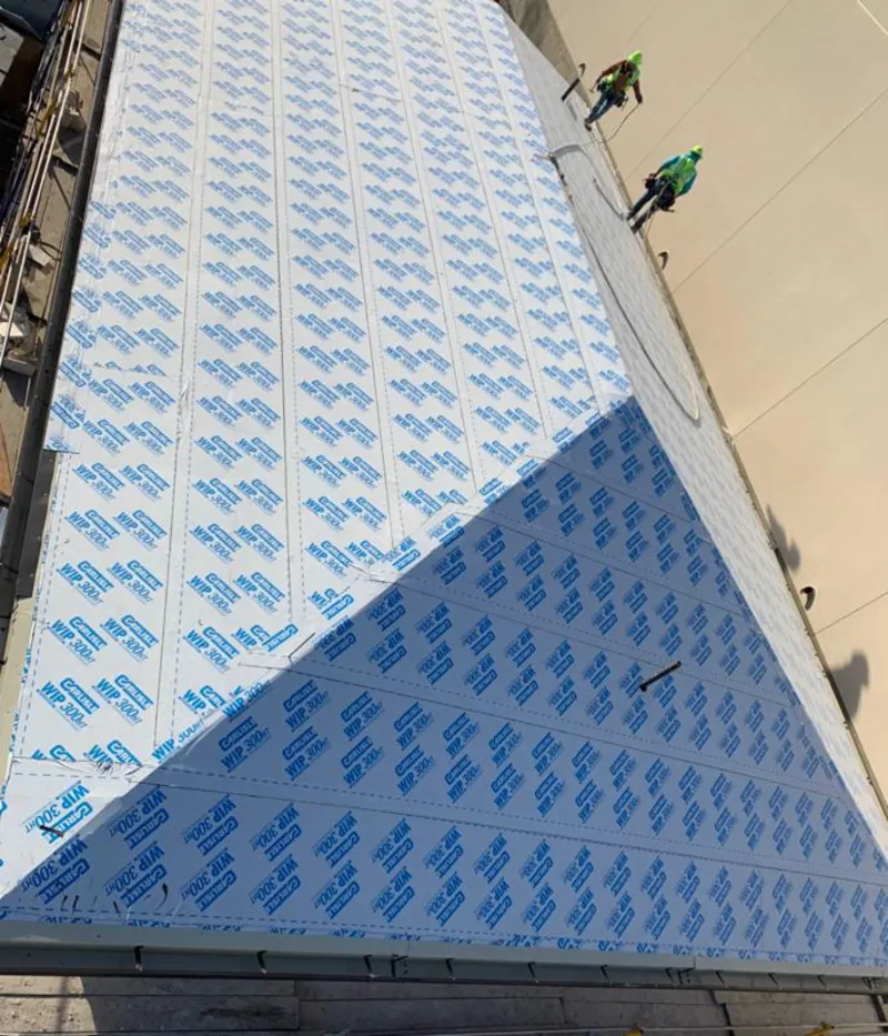 Professional roofers installing underlayment on a metal roof in White Bear Lake